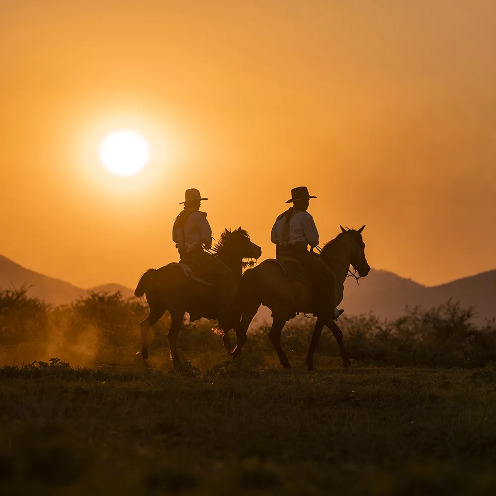 Texas sunset with two cowboys on horses
